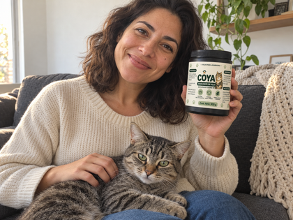 Mujer en el sillón con su gato mostrando el pote de COYA